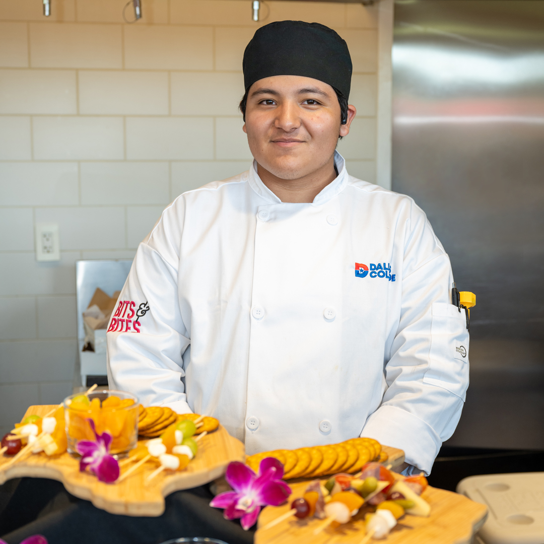 Culinary and Hospitality Student standing next to a dish at 2025 Bits and Bites