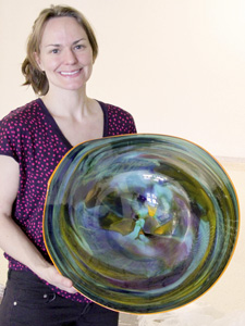 Photo of Rachel Haynes holding a glass blown roundel.